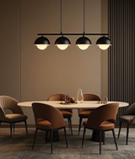 Round dining table with tan upholstered chairs under a row of pendant lights